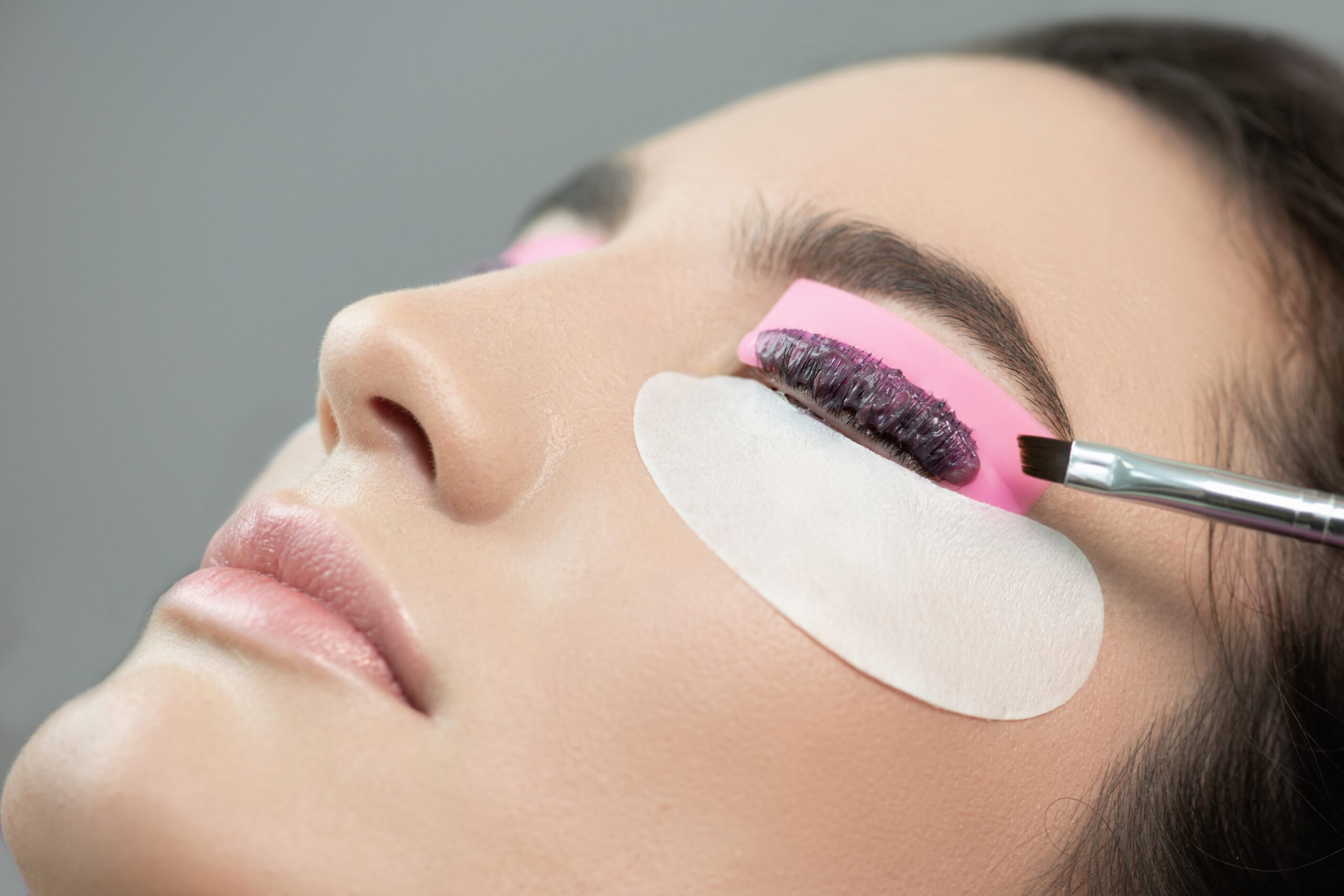 Master,Applies,Lash,Dye,To,Eyelashes.,Close-up,Of,Beauty,Model's