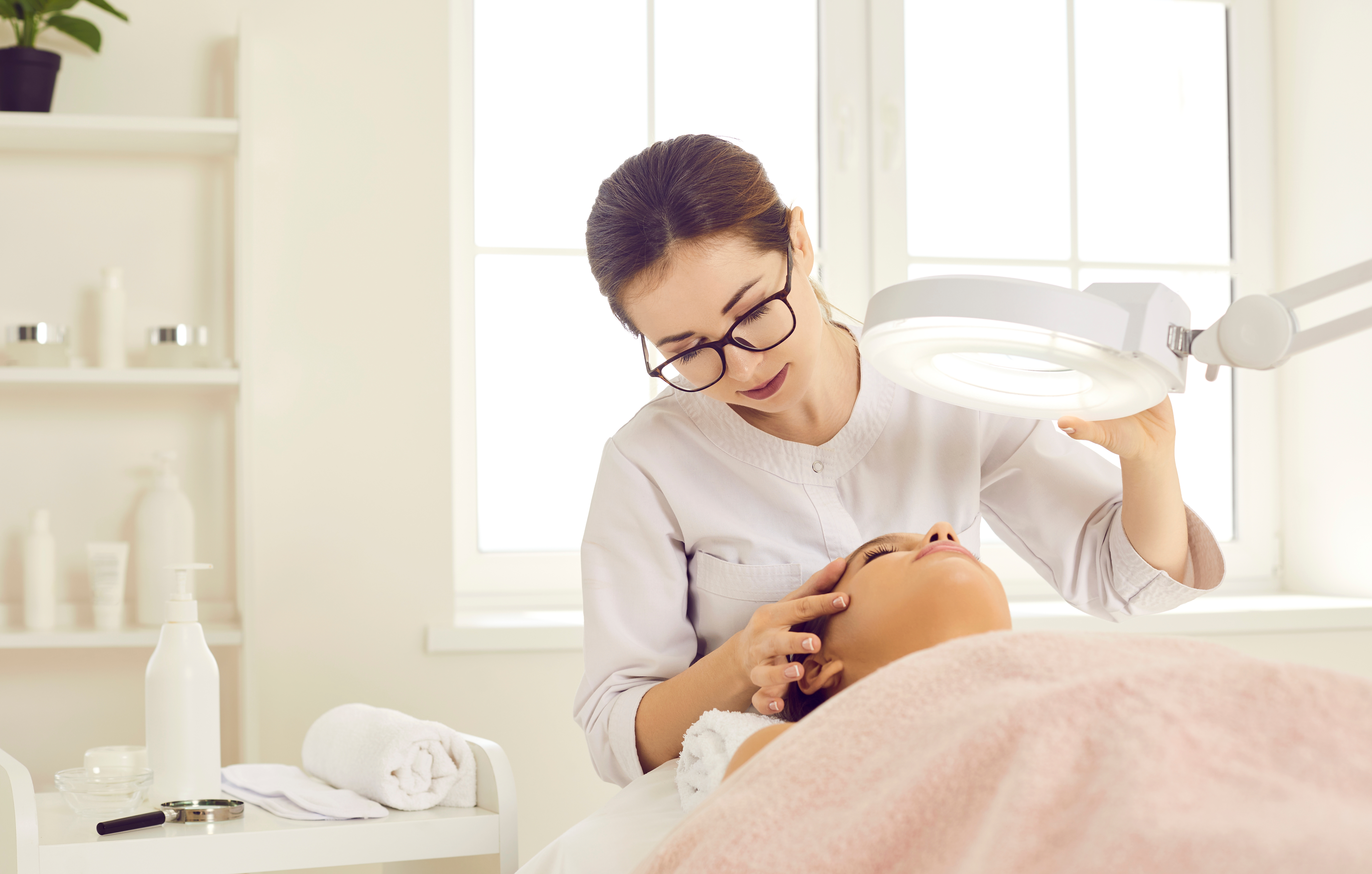 Dermatologist,,Skin,Therapist,,Or,Beautician,Looking,At,Patient's,Face,Under