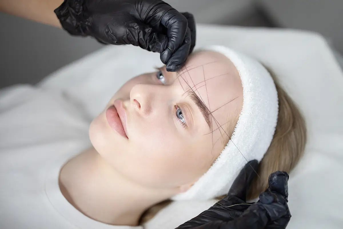 A relaxed woman getting facial cream spread on her face