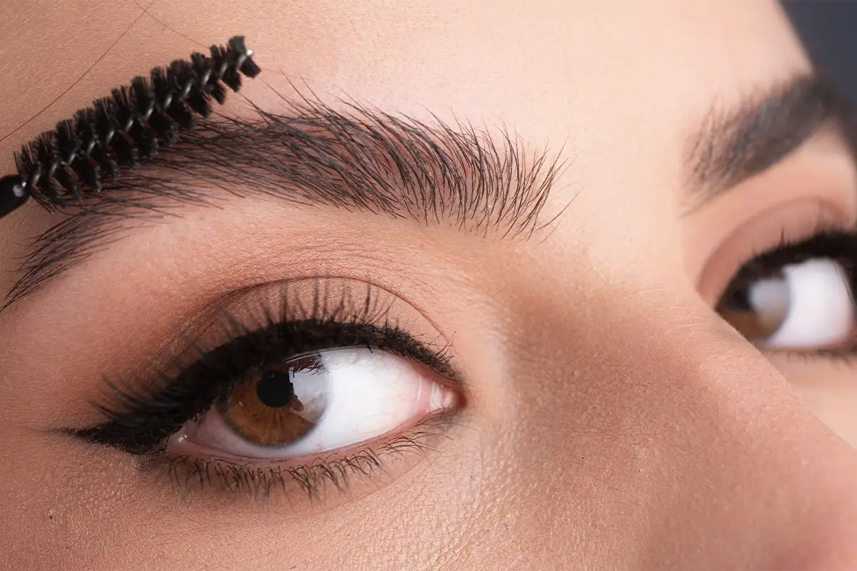 A relaxed woman getting facial cream spread on her face