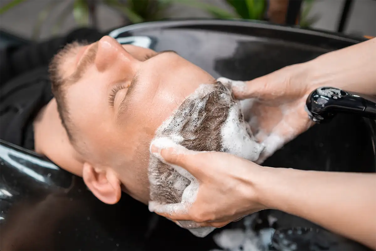 A relaxed woman getting facial cream spread on her face