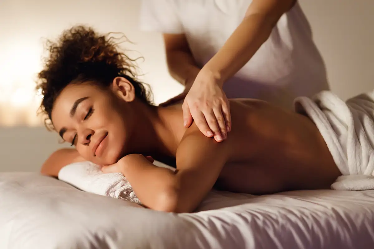 A relaxed woman getting facial cream spread on her face