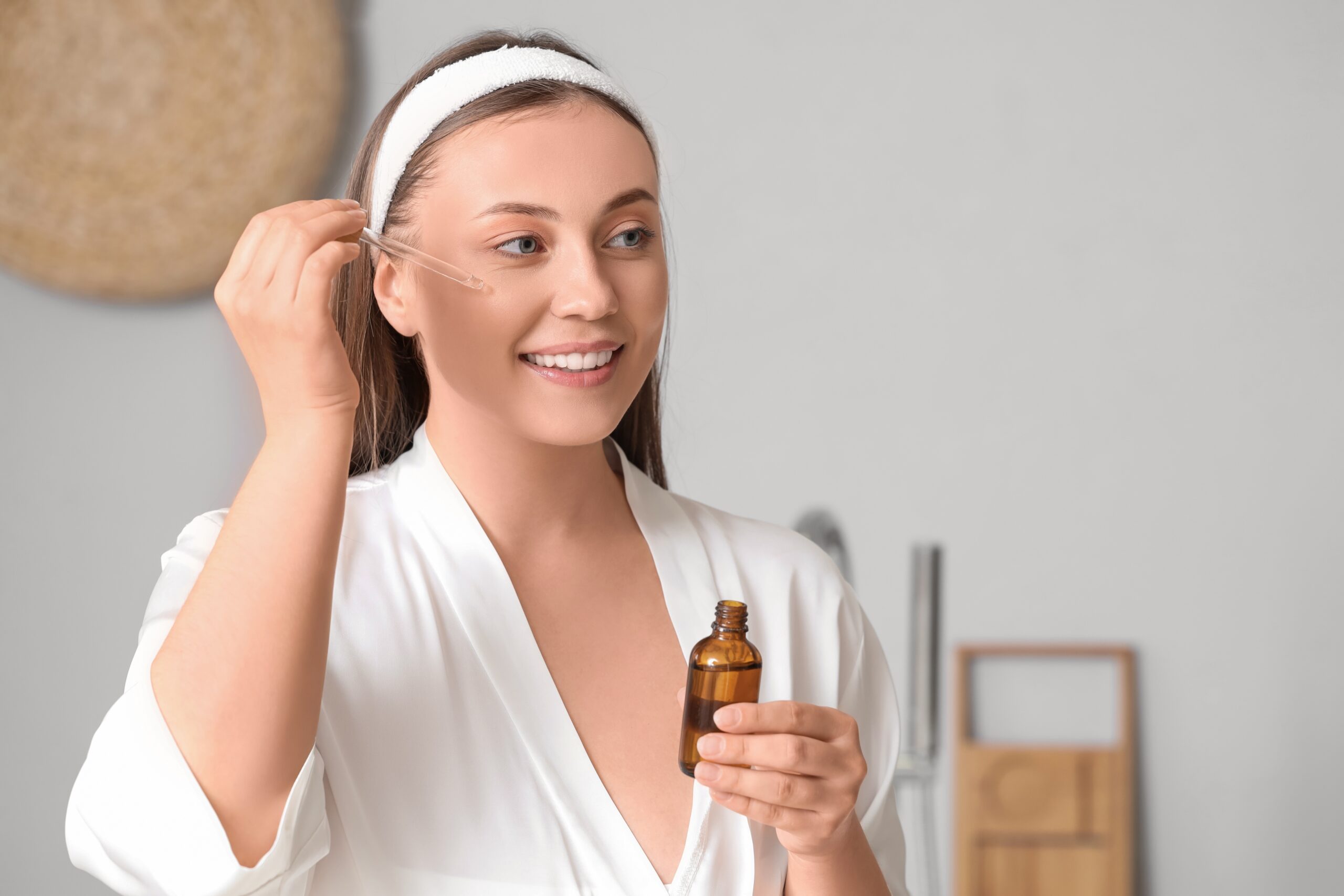 Girl applying Vitamin C serum on face in bright Florida morning light to boost skin radiance and protect against sun damage.