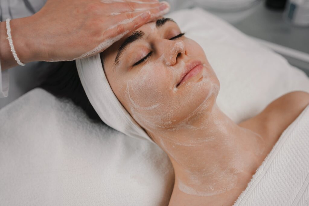 Esthetician performing a gentle facial treatment on a client with sensitive skin in a calm spa setting.