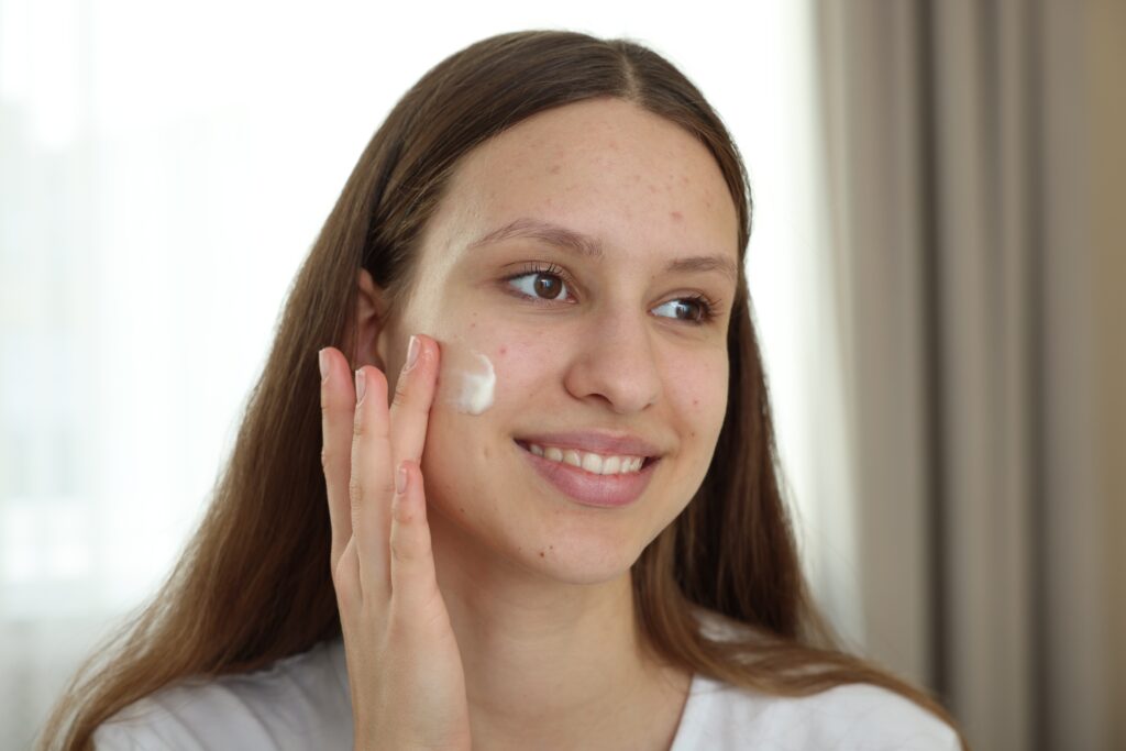 A young girl using skin treatment for her sensitive skin to reduce redness and irritation.