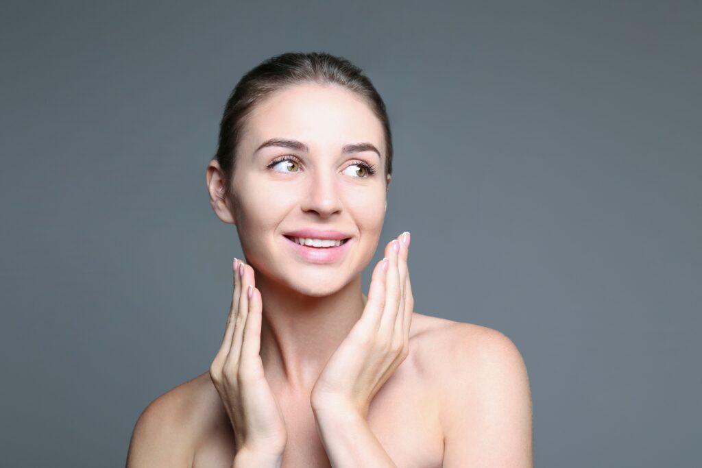 Client examining smoother skin texture after a professional facial treatment for enlarged pores.