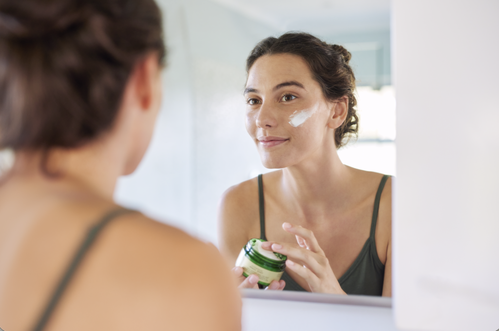 Woman applying a gentle moisturizer to support skin barrier recovery and restore hydration.