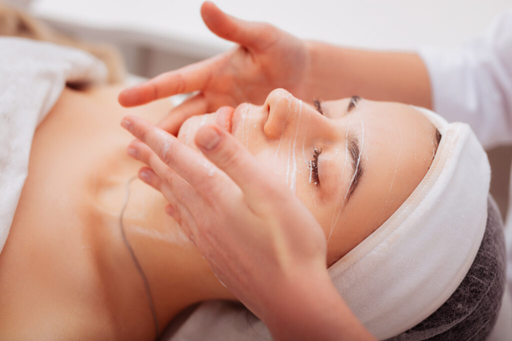 Esthetician performing a customized facial treatment to support hydration, firmness, and healthier-looking aging skin.