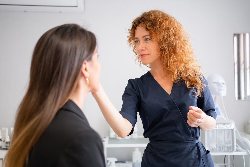 Esthetician discussing a client's dull-looking skin, hydration needs, and skincare routine during a consultation.